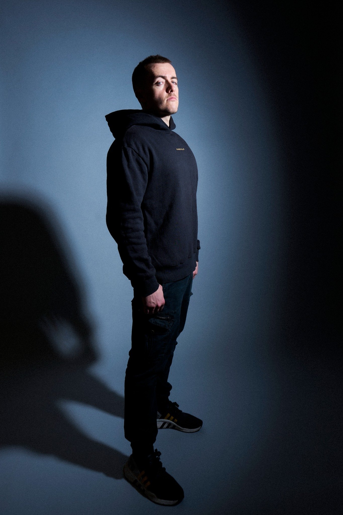 Mark Roma standing in a dark studio portrait